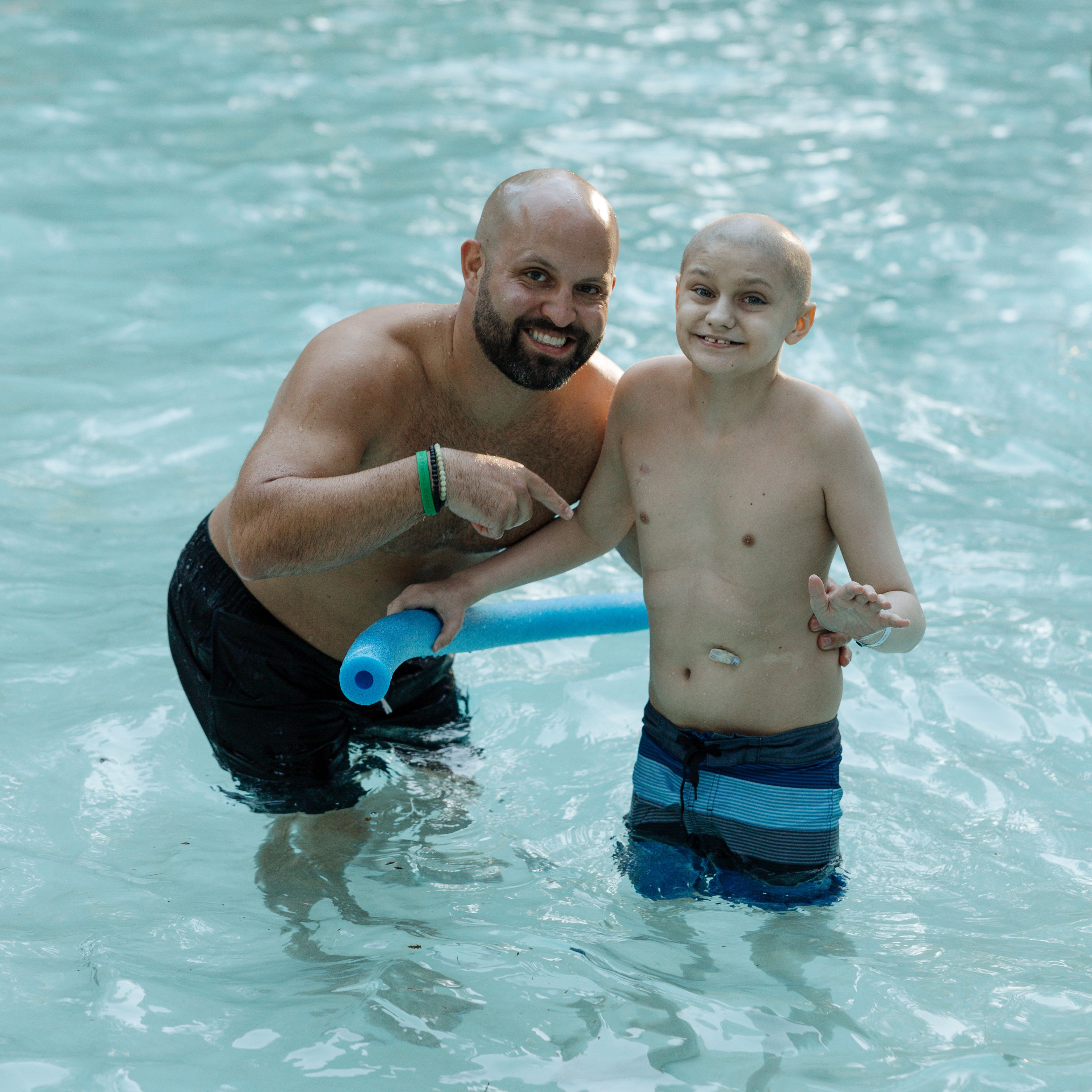 A volunteer and a camper in the pool 